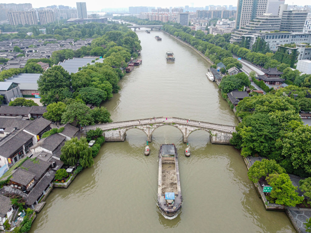 5月27日，一艘貨船駛過京杭大運(yùn)河南端標(biāo)志建筑杭州拱宸橋。(無人機(jī)照片)新華社記者江漢 攝