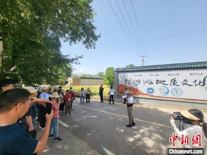 圖為中國地質(zhì)大學(xué)(北京)教授張緒教介紹村落情況?！『衍?攝